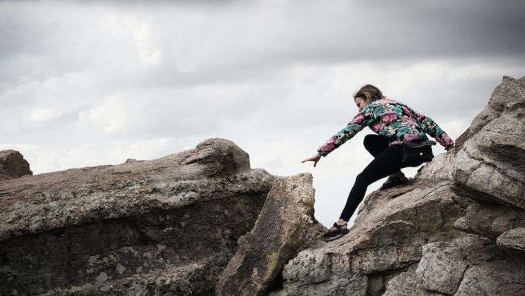 Woman cautiously navigating rocky path